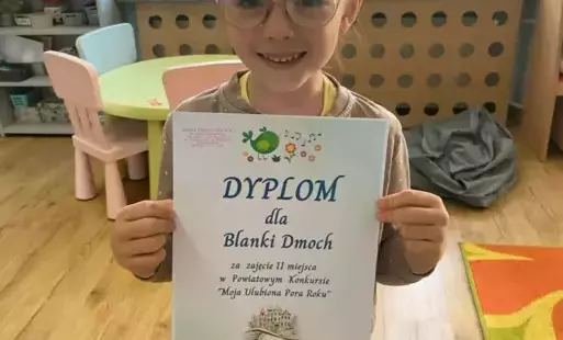 Dziewczynka w okularach z dyplomem